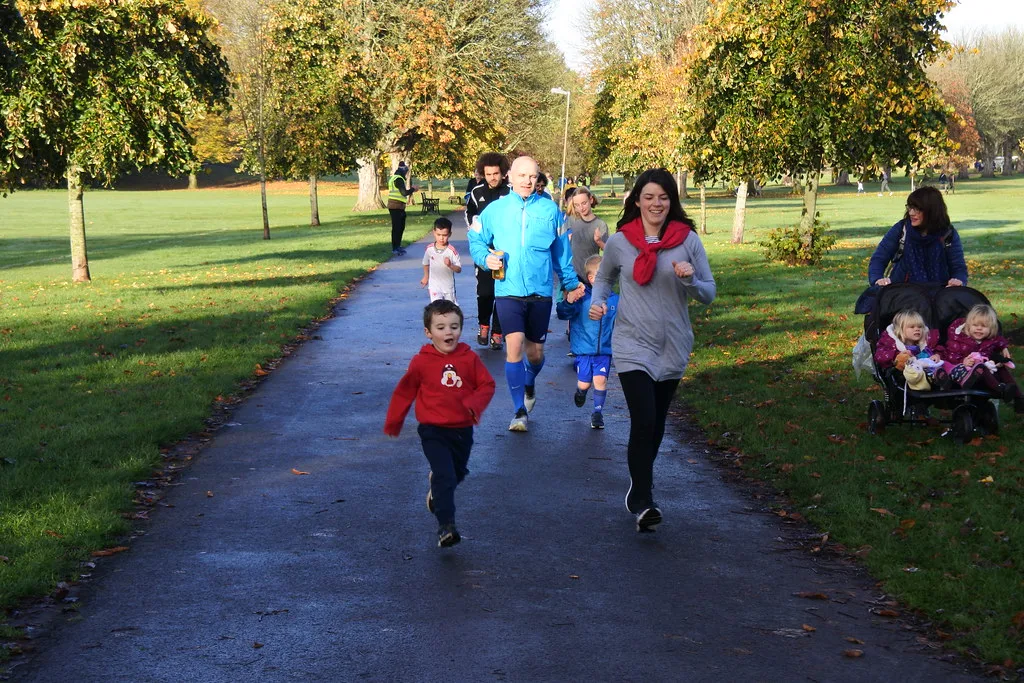 Children and parents running a junior parkrun in autumn. The picture is of the Cardiff event, not Harlow.